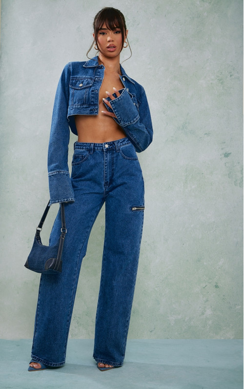 Середньо-блакитні прямі джинси на стегнах і блискавці